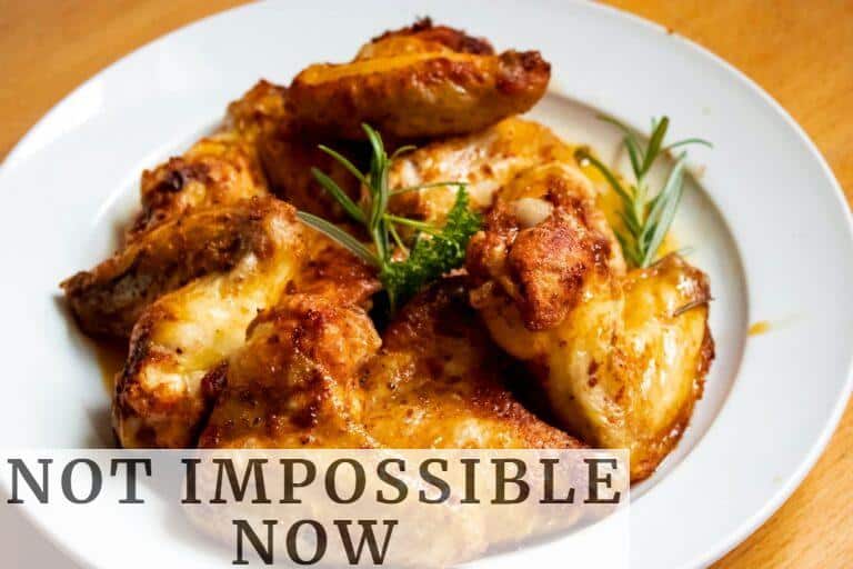 Golden-brown chicken wings garnished with fresh herbs, perfect for a tasty meal.