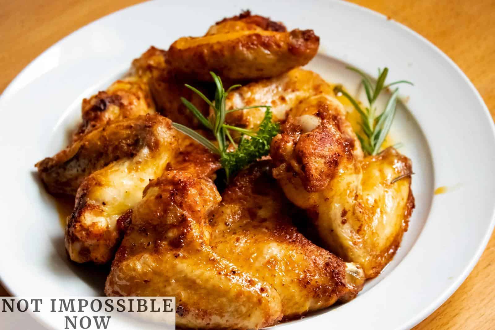 Golden-brown chicken wings garnished with fresh herbs, perfect for a tasty meal.
