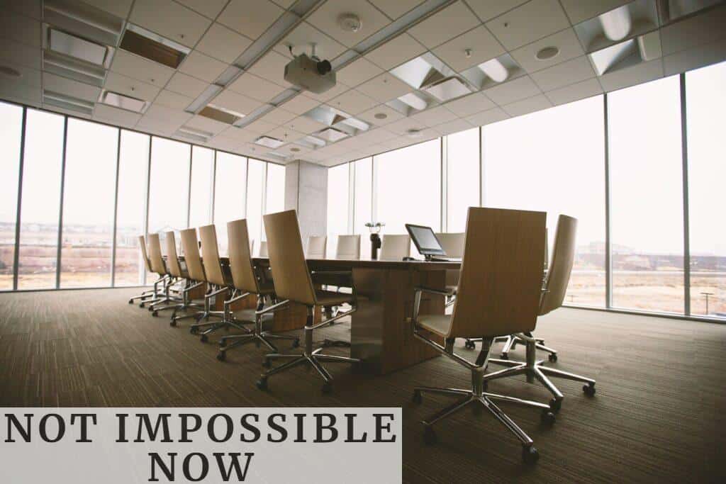 oval brown wooden conference table and chairs inside conference room