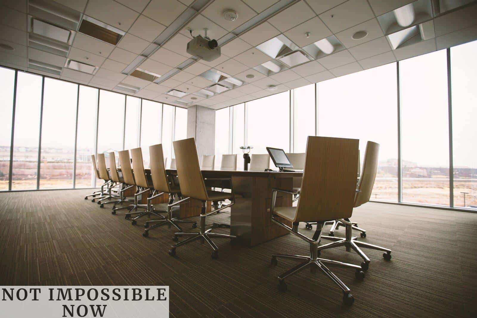 oval brown wooden conference table and chairs inside conference room