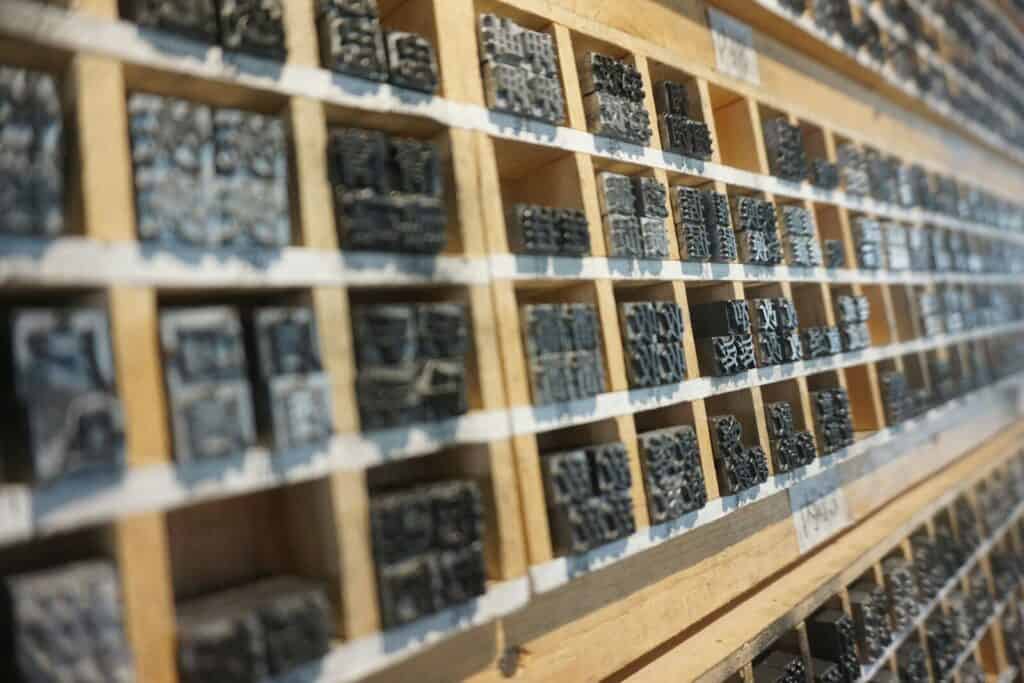 Muestras de piezas metálicas en estanterías para procesos de estampación.